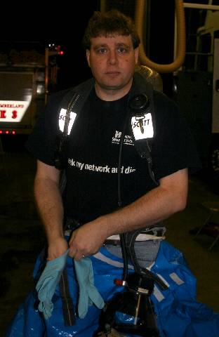 Andrew at the fire station wearing an airpack and putting on a class-b hazmat suit
